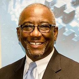 Jimmy Wilson a smiling man in his early 50s wearing a brown suithappy 